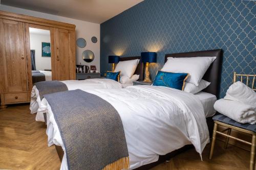 a bedroom with a large bed and a blue wall at The Brasenose Arms in Banbury