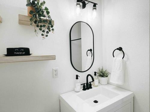 Baño blanco con lavabo y espejo en Cozy Home w/Tesla Charger & Near National Parks, en Sanger