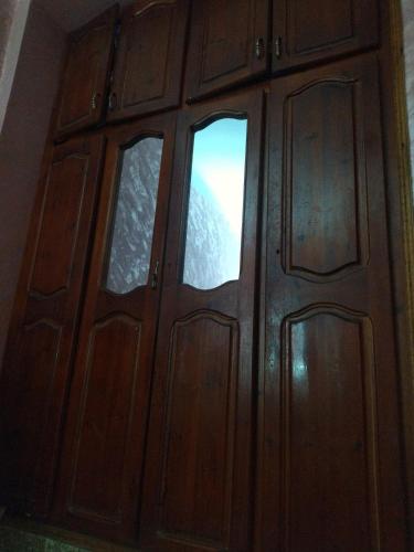 a wooden door with two windows in a room at Cité 1 novembre in Khemis Miliana