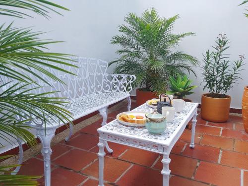 a white bench with a tray of fruit on it at Casita de Piedra in Bogotá