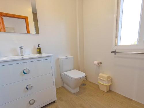 een witte badkamer met een toilet en een wastafel bij Apartamentos Chimenea in Nerja