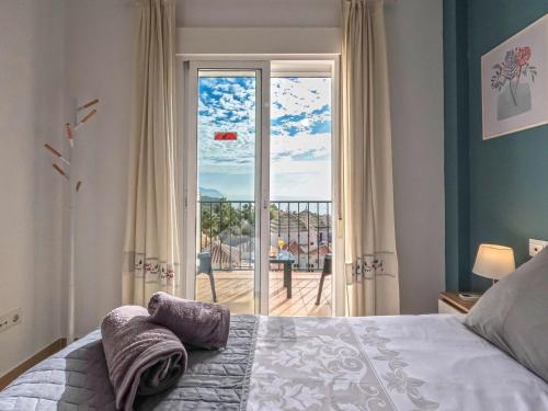 a bedroom with a bed and a sliding glass door at Apartamentos Chimenea in Nerja