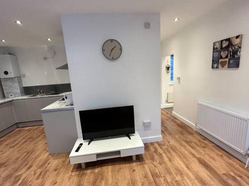 a living room with a tv on a white wall at Spacious 1-Bed Apt in Stretford in Manchester