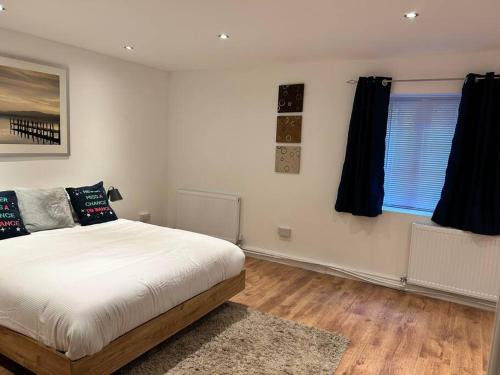 a bedroom with a bed and two windows at Spacious 1-Bed Apt in Stretford in Manchester