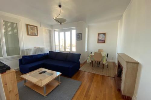 un salon avec un canapé bleu et une table dans l'établissement Haven of peace in the heart of Caen, à Caen