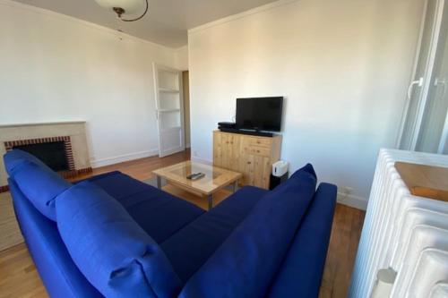 un salon avec un canapé bleu et une télévision dans l'établissement Haven of peace in the heart of Caen, à Caen