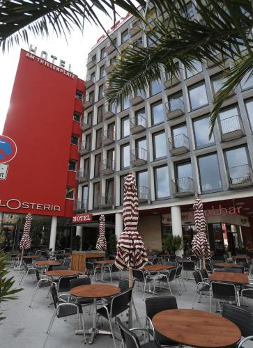 a group of tables and chairs in front of a building at Smartcity Designhotel in Hannover