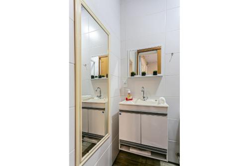 Baño con 2 lavabos y espejo en Studio aconchegante a 130m do mar TOCA152, en Florianópolis