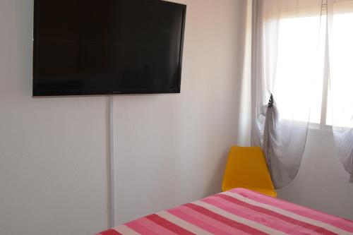 ein Schlafzimmer mit einem Bett und einem TV an der Wand in der Unterkunft Serena Moncofa in Moncófa