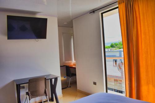 um quarto com uma cama e uma janela com vista em Hotel El Sol Inn em Aguachica