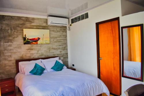 um quarto com uma cama com almofadas azuis em Hotel El Sol Inn em Aguachica