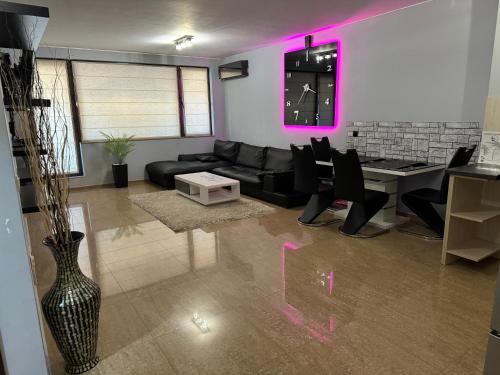 ein Wohnzimmer mit einem schwarzen Sofa und einem Tisch in der Unterkunft Apartments Las Tres Palmas in Sofia