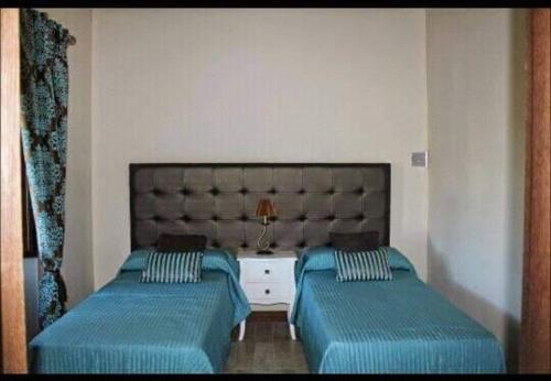 ein Schlafzimmer mit zwei Betten und einem Kopfteil in der Unterkunft Casa Rural Huerta Los Caños in Bienvenida