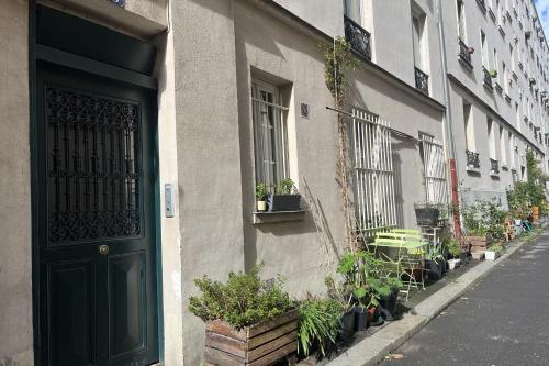 un bâtiment avec une porte verte dans une rue dans l'établissement Charming apartment in the heart of Paris, à Paris