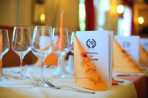 a table with wine glasses and a napkin on it at Hotel Pontivy in Wesseling