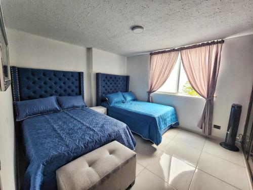 卡利的住宿－Apartamento en el Peñón - Oeste，一间卧室设有两张床和窗户。