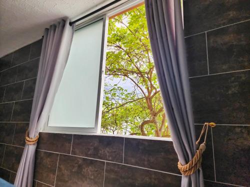 a window in a bathroom with a shower curtain at Apartamento en el Peñón - Oeste in Cali
