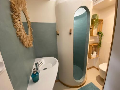 une salle de bain avec un lavabo et un miroir dans l'établissement Le Patio aux Oiseaux, à La Ciotat