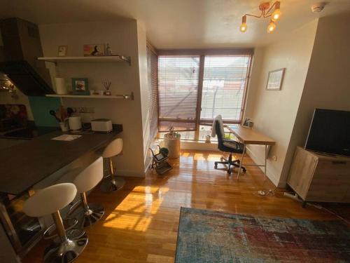 a living room with a table and a desk with chairs at Amazing flat in the heart of Manchester city centre! in Manchester