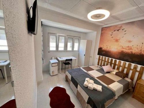 ein Schlafzimmer mit einem Bett und einem Schreibtisch. in der Unterkunft Novelda Centro Habitaciones con baño privado y compartido , cocina y terraza in Novelda