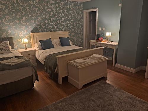 a bedroom with a bed and a desk with two lamps at Oak House Laois B&B in Portarlington