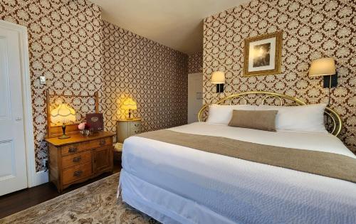 a bedroom with a large bed and two lamps at The Mason Cottage Downtown in Cape May