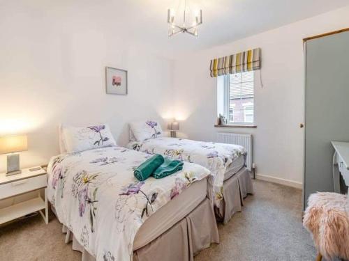 a bedroom with two beds and a window at Church Hall & Secret Garden Hideaway at Summer Hills Whitby in Whitby