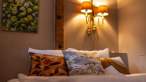 a bedroom with a bed with pillows and a lamp at Villa Maija 2 Southside in Hanko