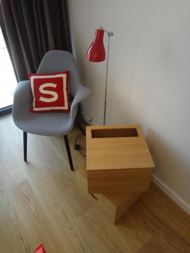 a chair with a pillow and a table in a room at Smartcity Designhotel in Hannover