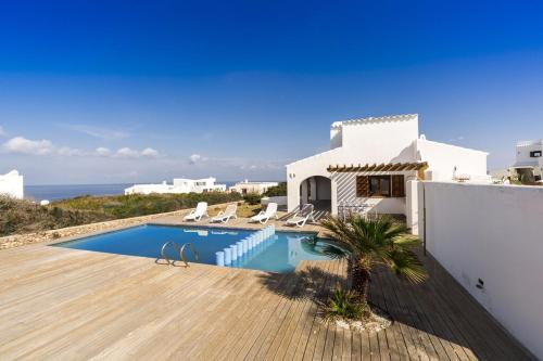 a villa with a swimming pool next to the ocean at Villa Amor in Cala Morell
