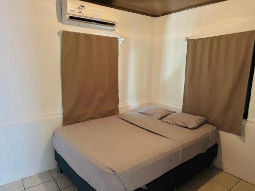 a small bed in a room with a window at Surf Paradise in Santa Teresa Beach