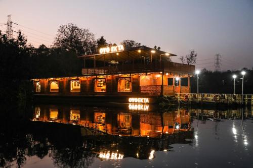 una casa flotante en el agua por la noche en Ekta Houseboat Statue Of Unity Kevadia, en Kevadia