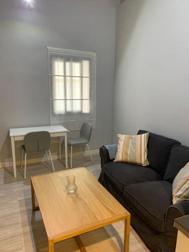 a living room with a couch and a table at Apartamento Pasaje in Seville