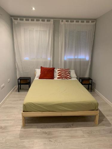 a bedroom with a large bed with two windows at Apartamento Pasaje in Seville
