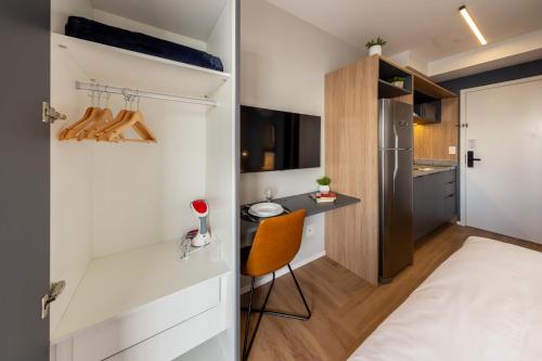 Un dormitorio pequeño con una cama y un escritorio. en Charlie Nik Vila Mariana, en São Paulo