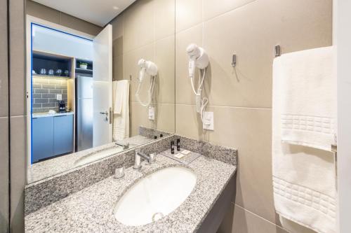 ein Bad mit einem Waschbecken und einem Spiegel in der Unterkunft Charlie Nik Vila Mariana in São Paulo