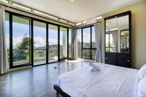 萬隆的住宿－Villa DagoResor Kanata 7BR 45peop Private Infinity Pool & Roof Garden，一间卧室设有床铺和大型玻璃窗
