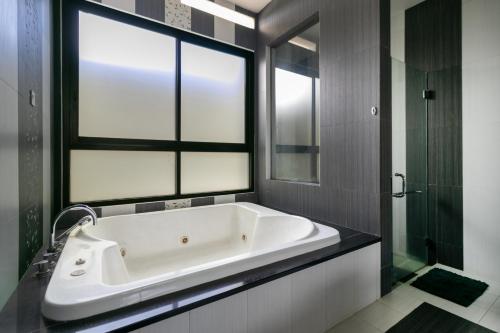 萬隆的住宿－Villa DagoResor Kanata 7BR 45peop Private Infinity Pool & Roof Garden，一间带大浴缸和窗户的浴室