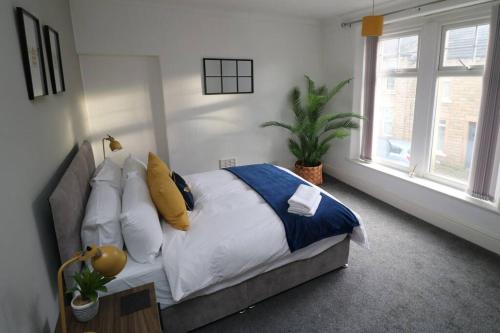 a bedroom with a bed with pillows and a plant at 2 Bedroom Characterful House in Lancaster