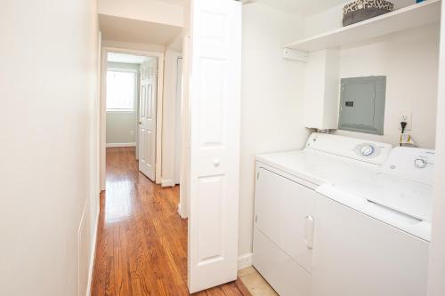 a white kitchen with a sink and a washing machine at Comfy and Cozy-Min to National Mall Great Location in Arlington