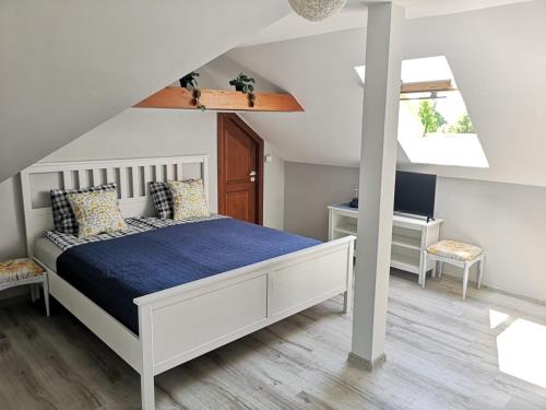 een slaapkamer met een wit bed en een bureau bij Apartament Wodna Ostoja z pokojem zabaw in Buczki