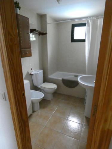 un bagno con un water, una vasca e un lavandino di VILLANUA ACOGEDOR PISO CON GARAJE, PADEL Y PISCINA a Villanúa
