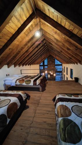 a bedroom with three beds in a room with wooden ceilings at Cabaña Luna Encantada in Mazamitla