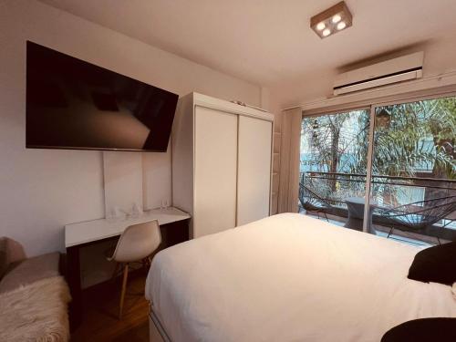 um quarto de hotel com uma cama e uma grande janela em Palermo Studio AROZ2323-1A em Buenos Aires