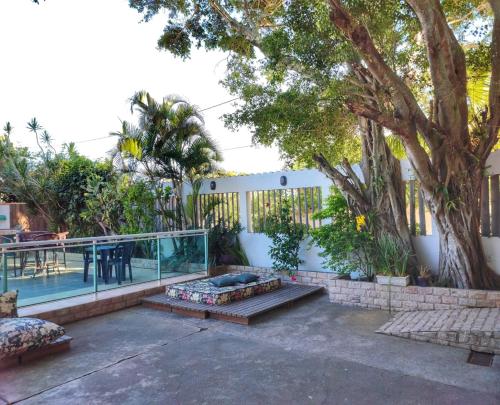 a patio with a table and a swimming pool at Pousada Recanto de Praia Seca in Araruama