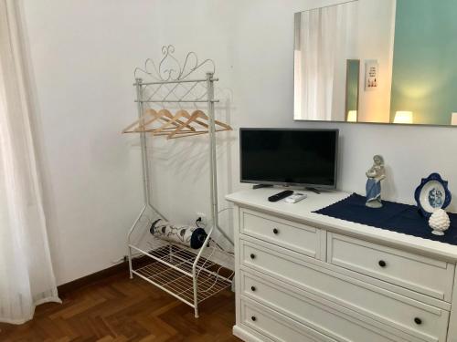 a room with a dresser with a television and a shelf at G&G ROOMS in Palermo