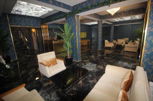 Safir Hotels Çorlu في كورلو: غرفة معيشة مع أريكة وطاولة وكراسي
