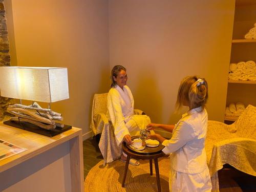a woman talking to a little girl in a room at HOTEL & SPA GASQUET in Luchon