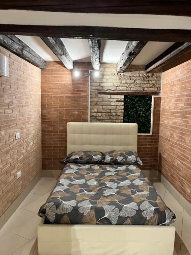 a bedroom with a bed in a brick wall at Venezia Holiday in Chioggia