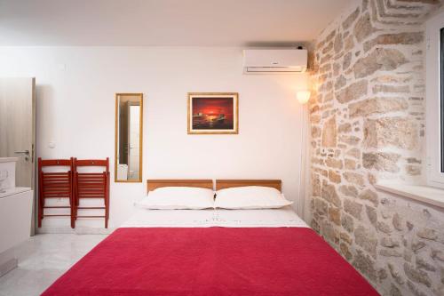 a bedroom with a bed with a red rug at Apartments Lotti 2 in Stari Grad